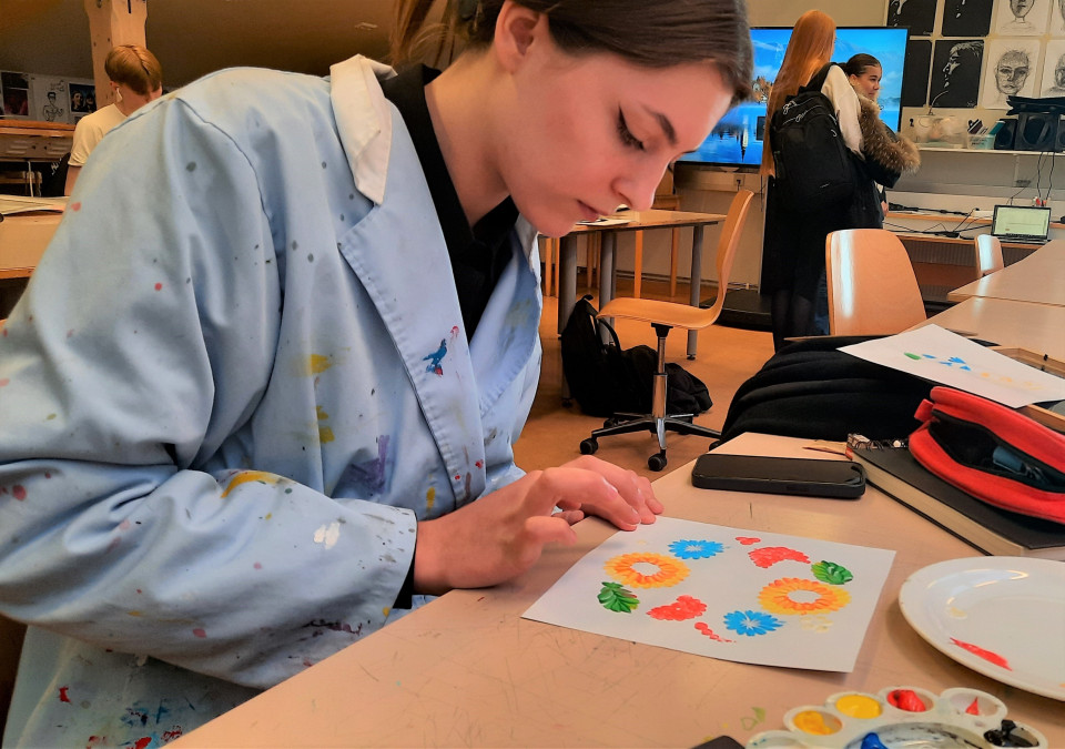 Málar Petrykivka myndir með penslum úr kattahárum Málar Petrykivka myndir með penslum úr kattahárum